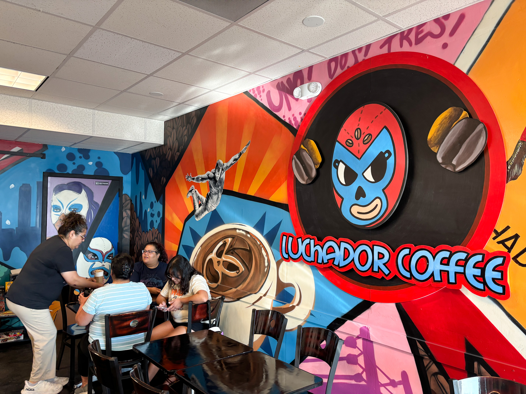Coffee shop worker serving community members at table